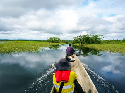 BMT environmental engineers in a canoe on a river in Papua New Guinea