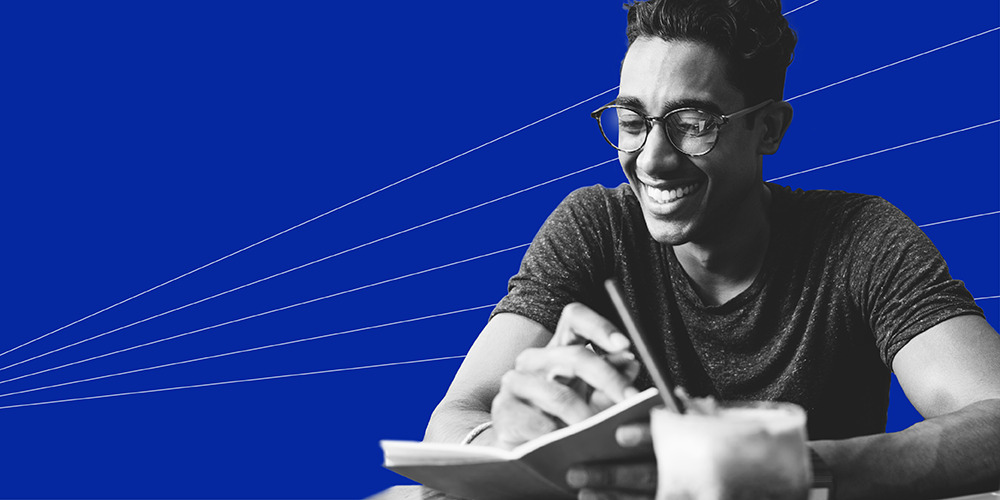 young man with glasses holding a pen and learning how to write a check