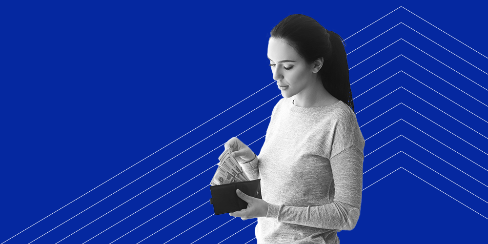 A woman with a ponytail in her hair sifting through cash in her wallet